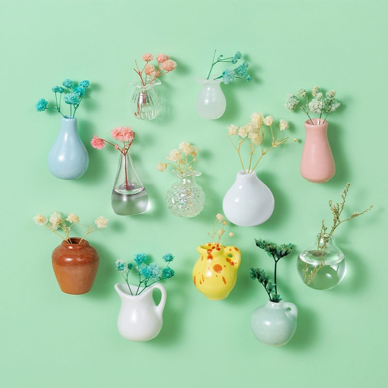 Collection of various small vases with plants on a light green background