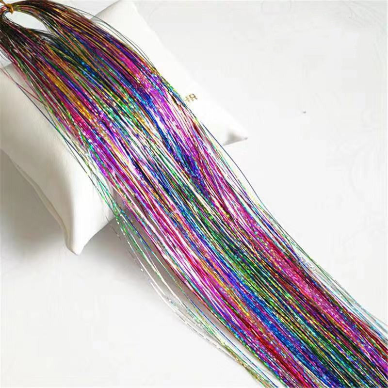 A collection of colorful laser hair color extensions displayed in a fan arrangement, including shades of red, green, blue, purple, and multicolor.