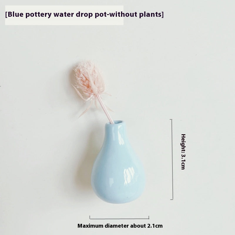 Blue pottery water drop pot with dried flowers on a white background