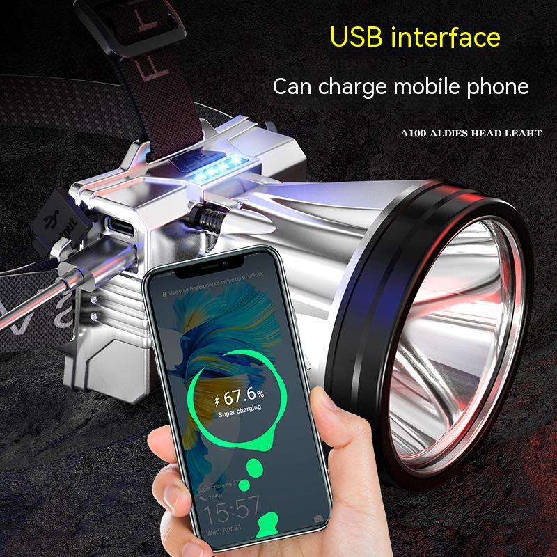 Handheld flashlight with USB interface charging a smartphone on a dark background