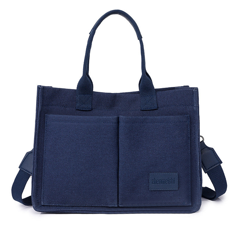 Navy blue tote bag with shoulder strap on a white background