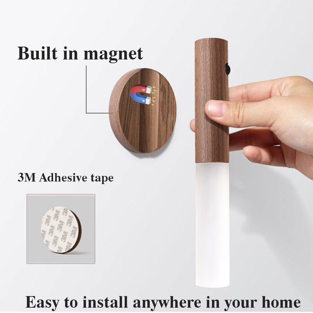 Wooden wall hook with magnetic and adhesive features, held by a hand on a white background.