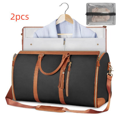 Black duffel bag with brown handles and straps, containing a shirt on a hanger and a mesh pouch.