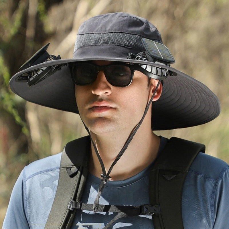 Person wearing a wide-brimmed black hat and sunglasses outdoors