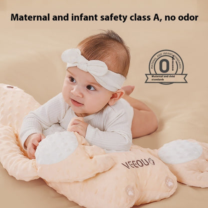 Baby lying on a soft, plush toy with 'VECOU' branding, against a beige background.